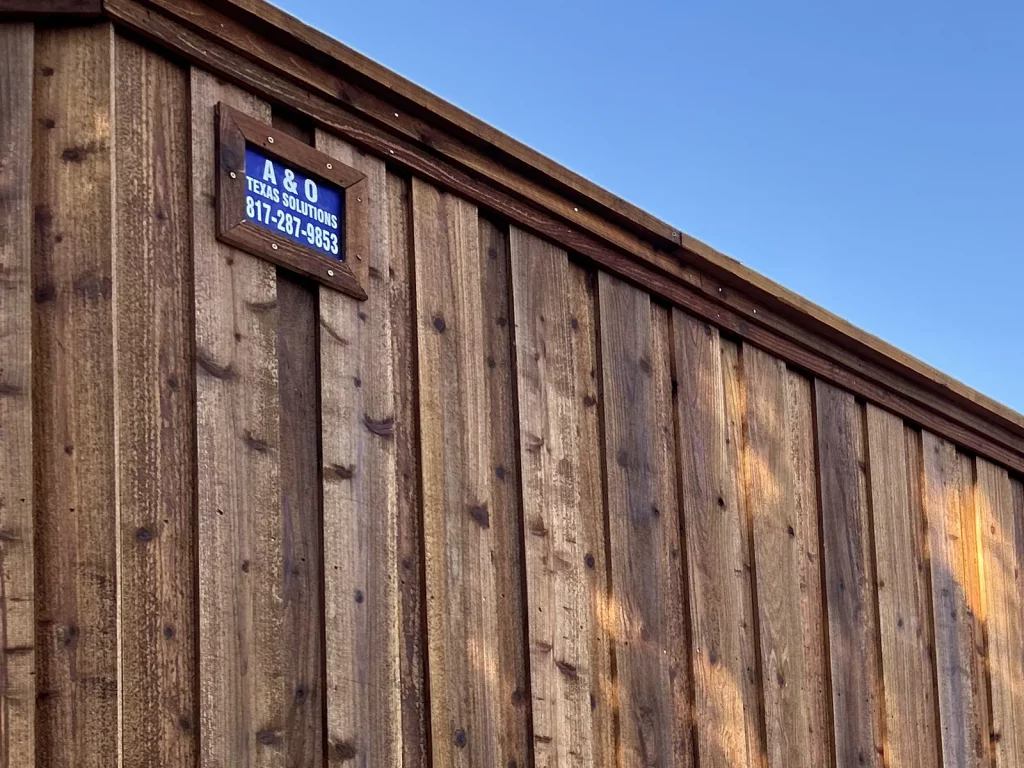 A&O Texas Solutions plaque mounted on a finished cedar fence in Plano, TX