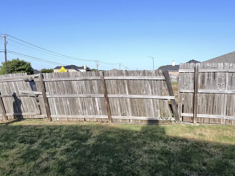 Failing grey wood fence line with separating boards before replacement in Arlington, TX