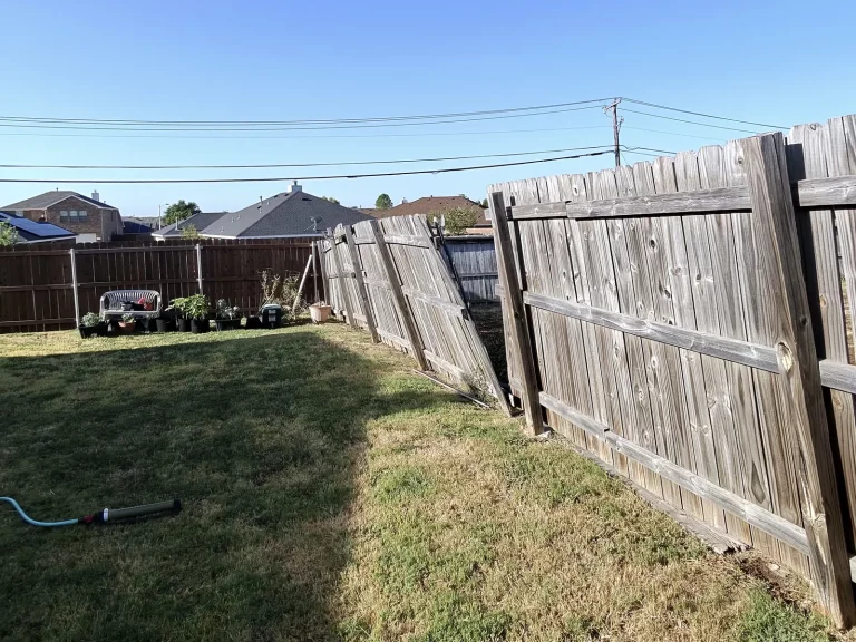 Old wood fence leaning into a backyard before cedar fence replacement in Arlington, TX