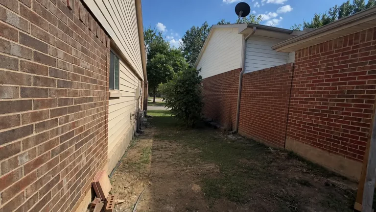Open side yard passage without a gate at an Irving, TX home before fence installation