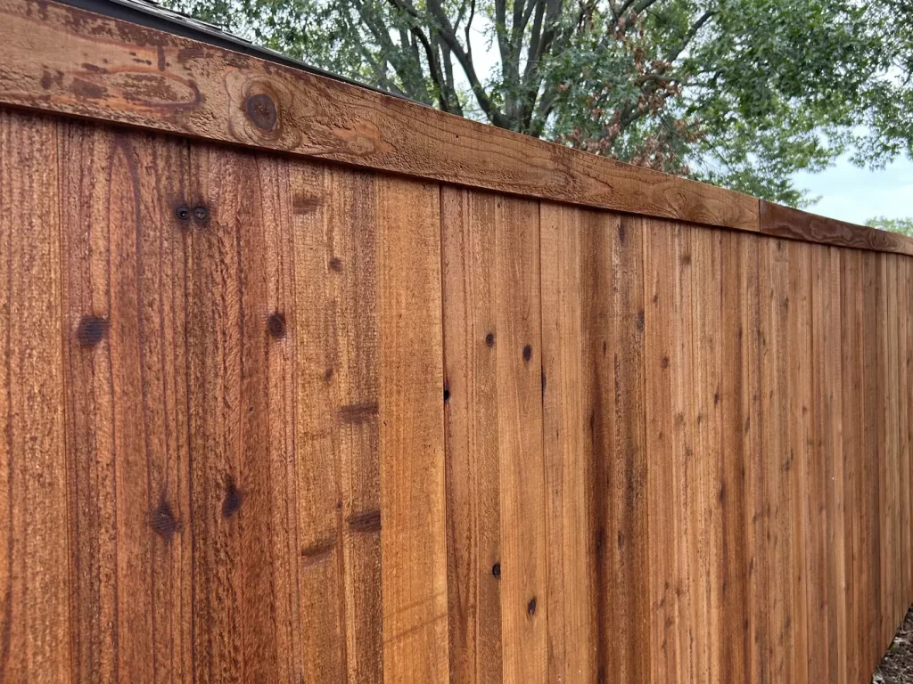 Horizontal cedar trim board capping the top of a new privacy fence in Arlington, TX