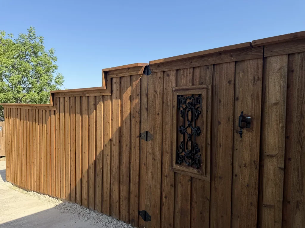 Finished cedar fence in Cedar Hill, TX with board-on-board pickets stepping down the grade to a gate