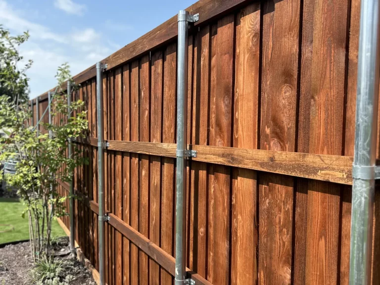 Rail side of a new cedar fence in Fort Worth, TX showing the galvanized steel posts and cedar rails