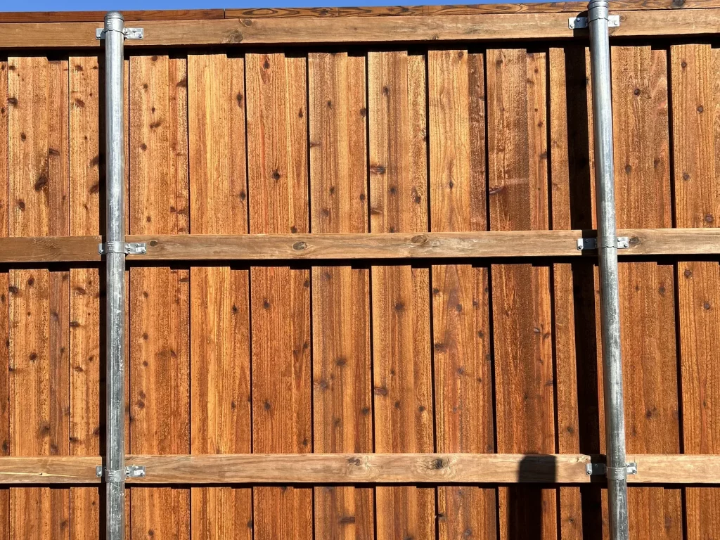 Rail side of a cedar fence in Plano, TX showing the galvanized metal posts and cedar rails