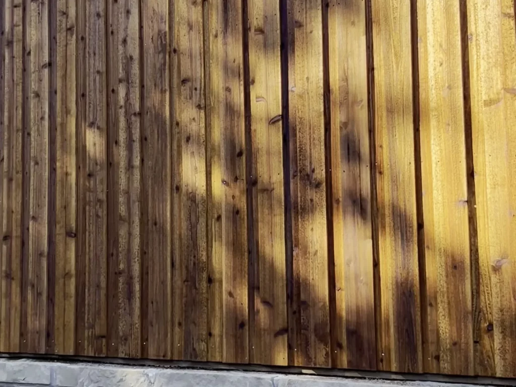 Cedar fence in Plano, TX built directly on top of an existing stone retaining wall