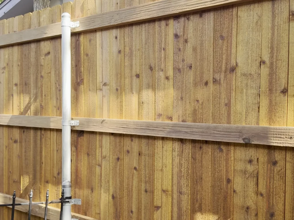 Three pressure-treated rails framing a cedar fence in Arlington, TX