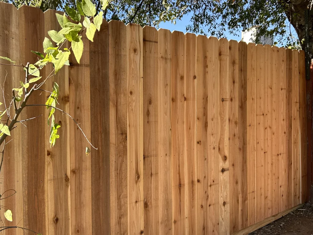 Finished cedar fence replacement in Arlington, TX with 6 ft natural side by side pickets along a backyard boundary