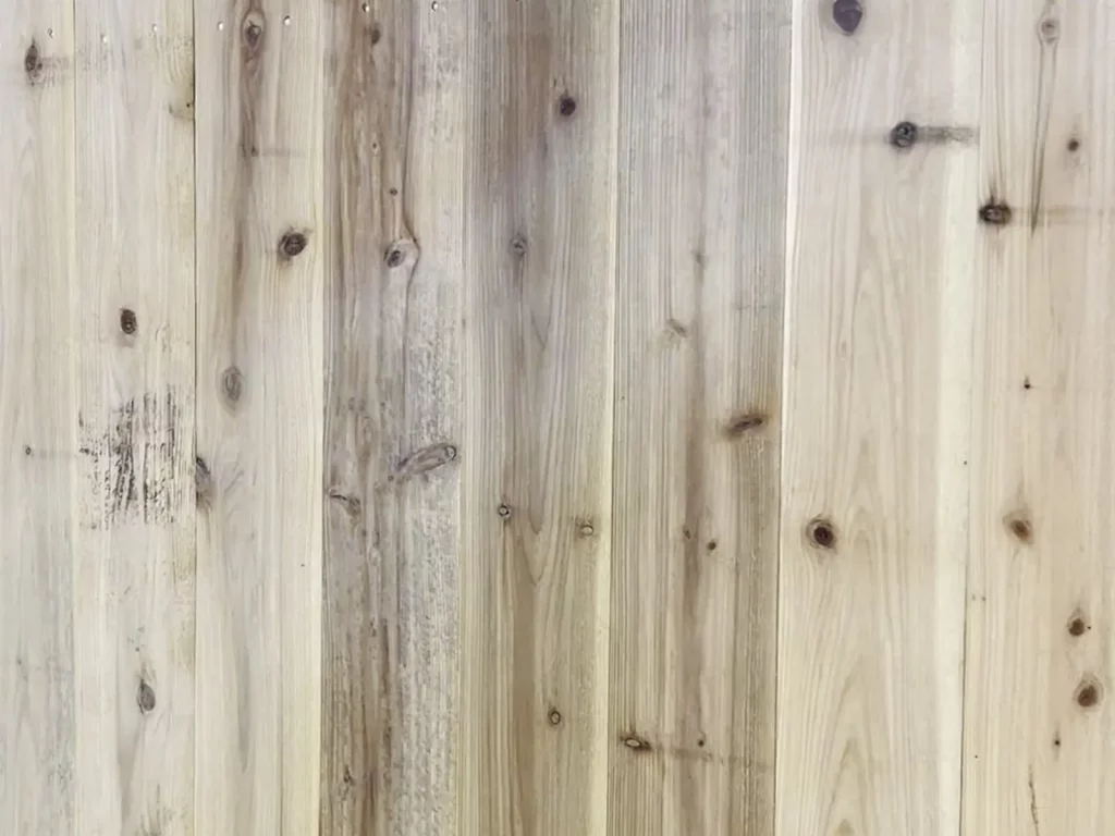 Close view of new cedar pickets and dog-ear tops on a privacy fence in Arlington, TX
