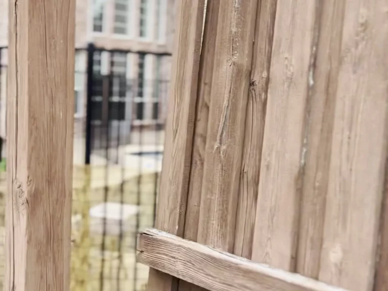 Split picket and weathered rail on a failing wood fence before replacement in Murphy, TX