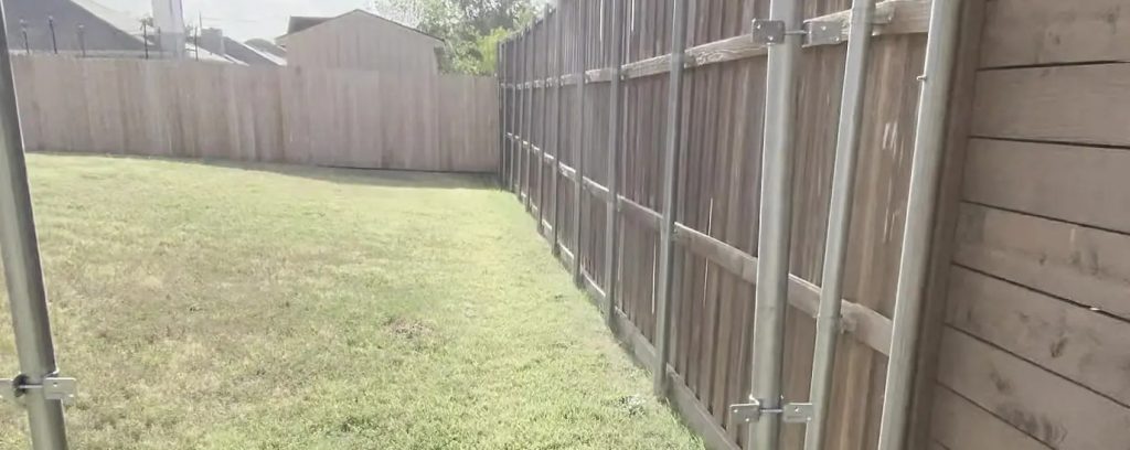 Galvanized steel fence posts and pressure-treated baseboard installed in Arlington, TX