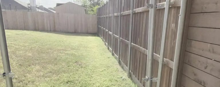 Galvanized steel fence posts and pressure-treated baseboard installed in Arlington, TX