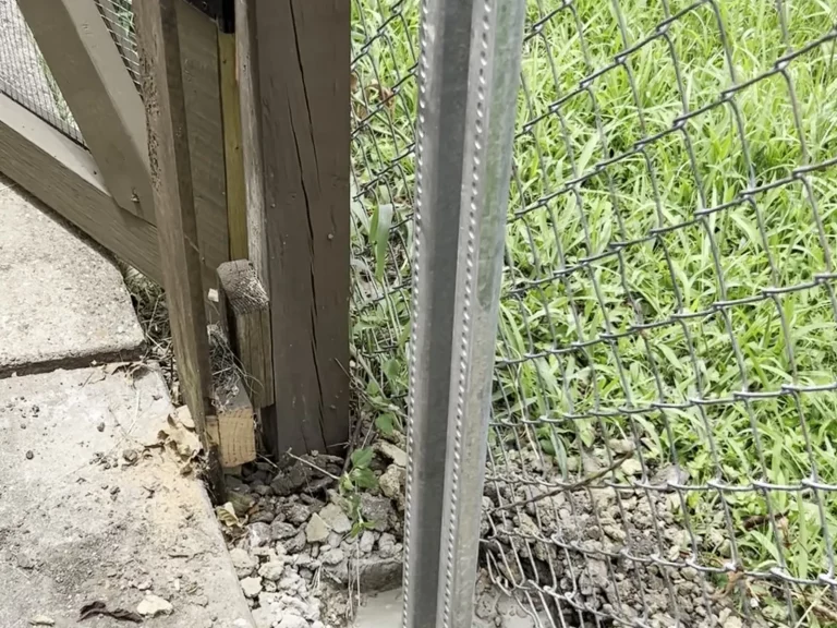 New galvanized steel fence post set in fresh concrete beside an old wood post in Fort Worth, TX