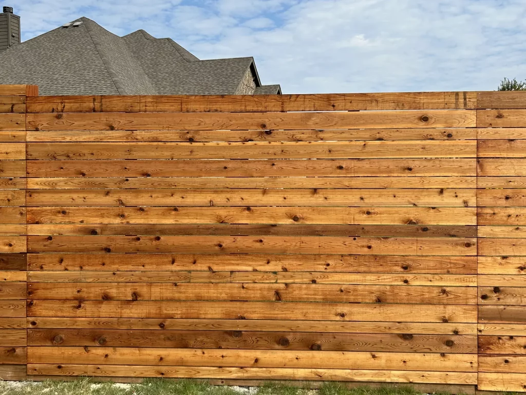 Close view of horizontal cedar boards and the steel post on a modern privacy fence in [City], TX