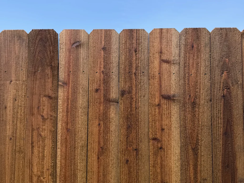 Close view of medium brown stained cedar pickets with dog-ear tops in Arlington, TX