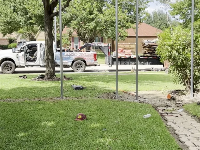 Metal fence posts set in concrete along the line before cedar pickets are installed in Mansfield, TX