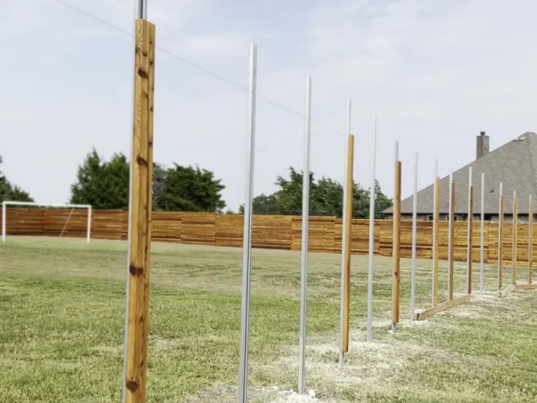 Galvanized steel fence posts set in fresh concrete along a new fence line in [City], TX