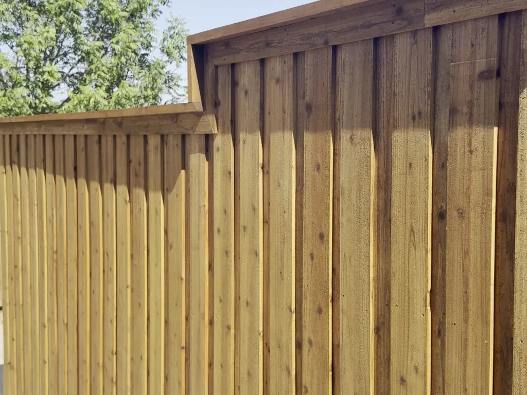 Stepped cedar fence run following the grade along a walkway in Cedar Hill, TX