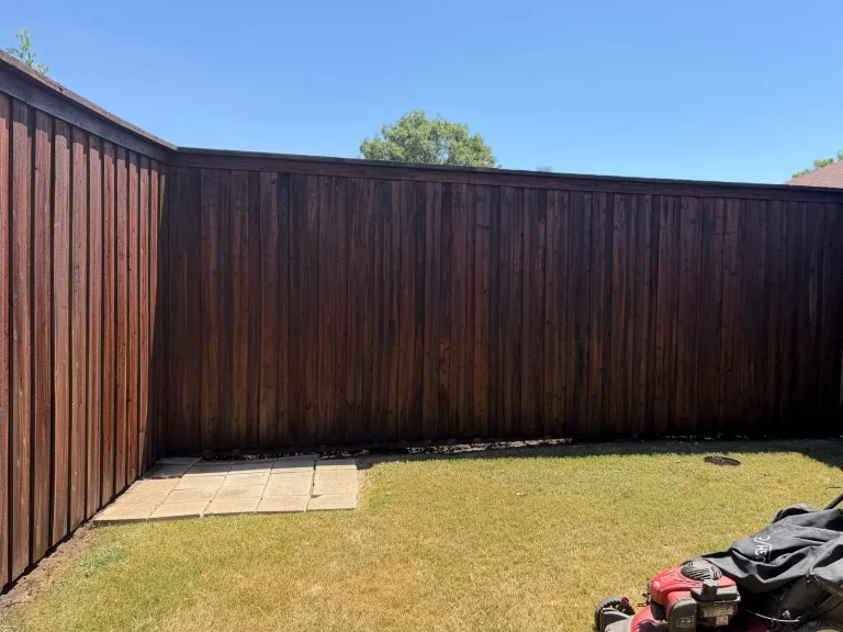 Wood fence stain in DeSoto, TX seen across the backyard corner