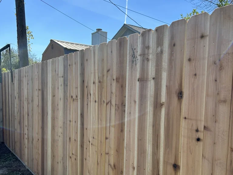 Tall mahogany-stained cedar privacy fence finished in a backyard in Arlington, TX