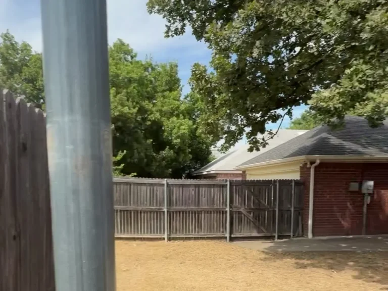 New cedar fence posts set along a row of homes during a cap and trim replacement in Arlington, TX