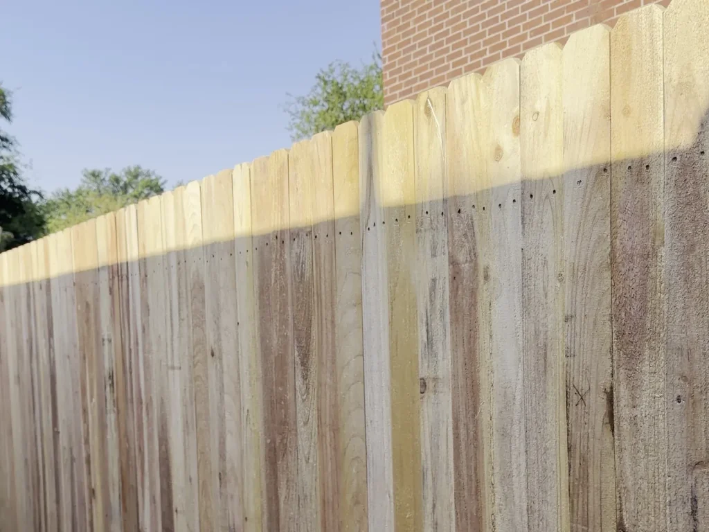 Cedar run of a cedar and wrought iron fence in Irving, TX seen down its length