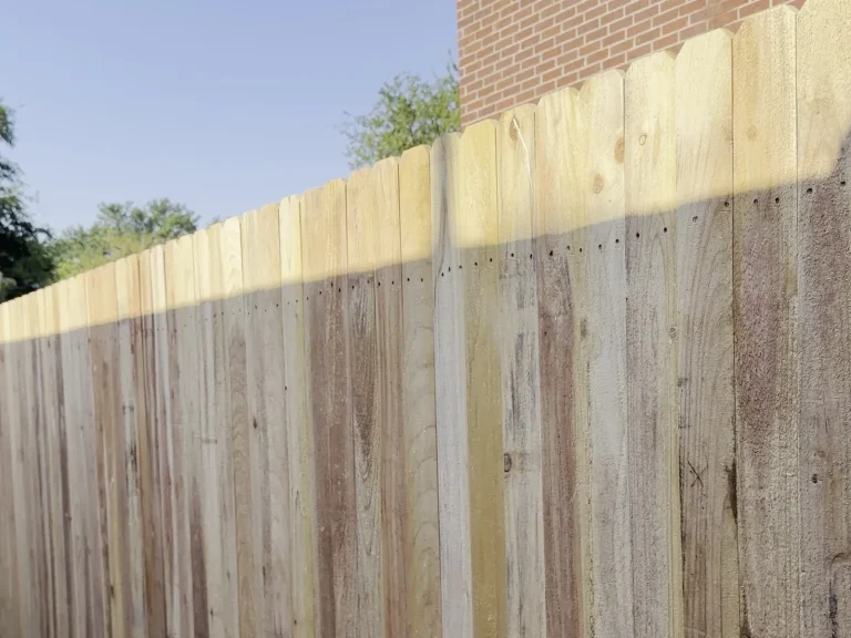 Cedar run of a cedar and wrought iron fence in Irving, TX seen down its length